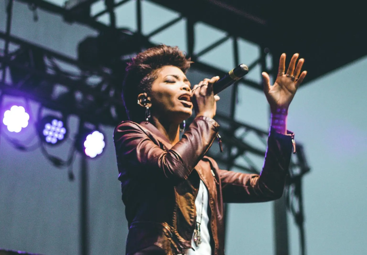 selective focus photography of woman raising left hand